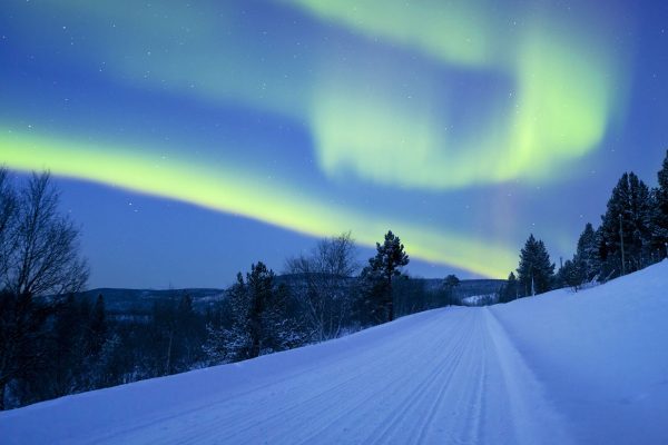 Beautiful northern lights (aurora borealis) over a road.